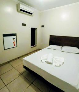 una camera da letto con un letto con due asciugamani sopra di Motel Suítes a Panorama