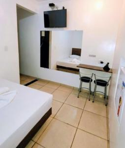 una camera con un letto e un tavolo e due sedie di Motel Suítes a Panorama
