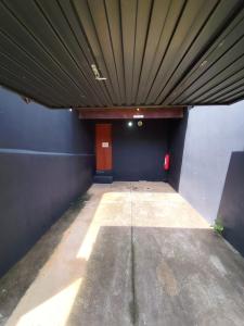 un garage vuoto con una parete blu e un soffitto in legno di Motel Suítes a Panorama