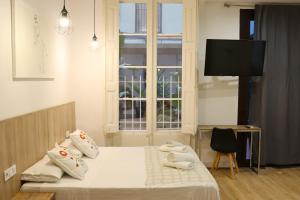 a bedroom with a bed and a tv and a window at lullaby by hamilton in Barcelona