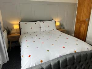 a bed with a white comforter with hearts on it at Delightful 1 Bedroom Cottage in Buxton