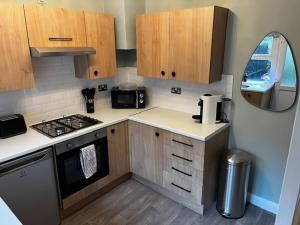 a small kitchen with a stove and a sink at Delightful 1 Bedroom Cottage in Buxton