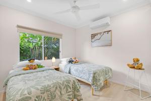 two beds in a room with teddy bears on them at Eden House Kewarra Beach in Kewarra Beach