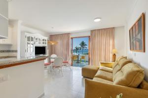 ein Wohnzimmer mit Sofa und eine Küche in der Unterkunft Playa Delphin 205 in Puerto Naos