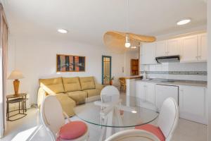 eine Küche und ein Wohnzimmer mit einem Glastisch in der Unterkunft Playa Delphin 205 in Puerto Naos