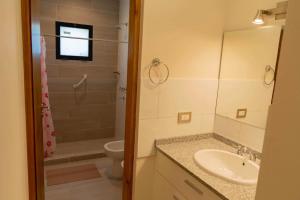 ein Badezimmer mit Waschbecken, Toilette und Dusche in der Unterkunft Casabella total confort y relax in Villa Elisa