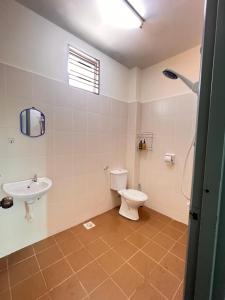een badkamer met toilet en wastafel bij Homestay 76 in Mersing +4 foto's