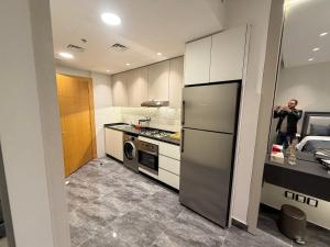 um homem tirando uma foto de uma cozinha em ستديو فندقي برج داماك بوليفارد العبدلي em Amã