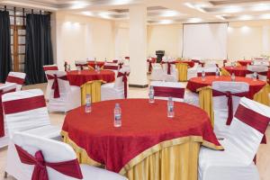una sala conferenze con tavoli e sedie rossi e bianchi di Riverside Resorts a Devaprayāg