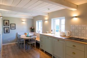 a kitchen with a table and a dining room at Ferienwohnung Steuerbord Steinbergkirche in Steinbergkirche