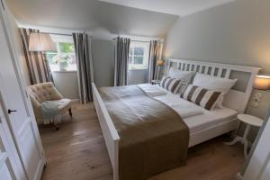 a bedroom with a white bed and a chair at Ferienwohnung Steuerbord Steinbergkirche in Steinbergkirche +23 photos