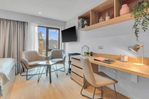 a room with a desk and chairs and a bedroom at The Bonnie in Glasgow