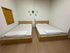 two twin beds in a room with a window at đất phú homestay phú yên in Ða Ngủ (2)