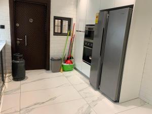 eine Küche mit Edelstahlkühlschrank und Backofen in der Unterkunft Pearlmab villa in Tema