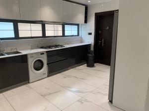 eine Küche mit Waschmaschine in der Unterkunft Pearlmab villa in Tema
