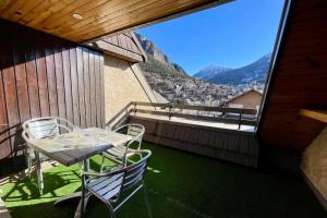 Una mesa y sillas en un balcón con vista. en Beautiful studio with magnificent view, en Briançon