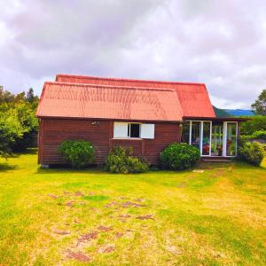 a small house with a red roof in a field at Bienvenue chez Gaston in Le Tampon