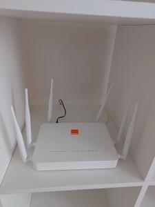 a white router sitting on top of a shelf at Apartment kamal park G39 in Mohammedia +3 photos