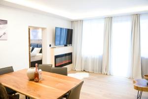 a living room with a wooden table and a television at NĀVA PLACE Cozy home in Kaprun in Kaprun