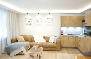 a living room with a couch and a kitchen at NĀVA PLACE Cozy home in Kaprun in Kaprun