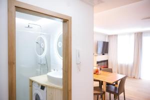 a bathroom with a sink and a table with a washing machine at NĀVA PLACE Cozy home in Kaprun in Kaprun