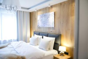 a bedroom with a bed with white sheets and pillows at NĀVA PLACE Cozy home in Kaprun in Kaprun