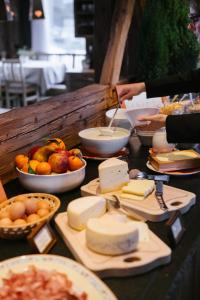 a table with cheese and other food on it at Bio Alpine Hotel Gran Fodà in San Vigilio Di Marebbe +49 photos