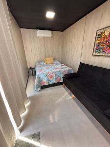 une petite pièce avec un lit et un canapé dans l'établissement Container - Pura Vida, à Uruçuca