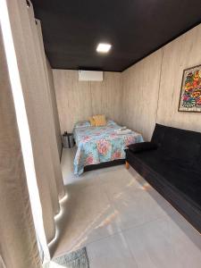 une petite pièce avec un lit et un canapé dans l'établissement Container - Pura Vida, à Uruçuca