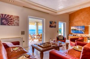 uma sala de estar com um sofá e uma mesa em Villa Aeolos em Barbati