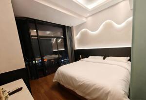 毕节Good dream Hotel的卧室里有一张白色的床和一扇大窗户