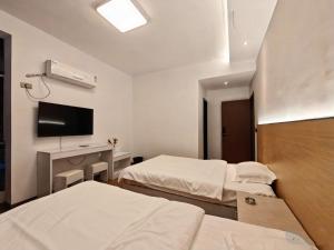 毕节Good dream Hotel的一间有两张床和一台电视的酒店房间 更多3张照片