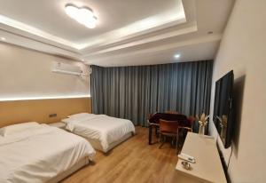 毕节Good dream Hotel的一间有两张床和一台电视的酒店房间