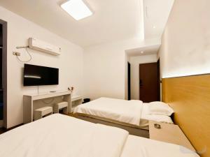 毕节Good dream Hotel的一间酒店房间，里面有两张床和一张桌子。