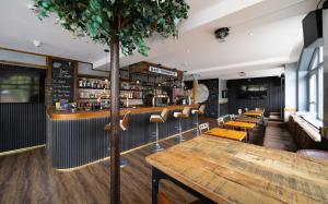 a restaurant with a bar with a table and chairs at Harbour Hub Hotel in Southampton