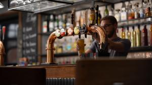 a man sitting at a bar with a drink at Harbour Hub Hotel in Southampton +25 photos
