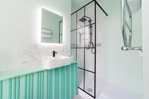 a bathroom with a sink and a shower at Harbour Hub Hotel in Southampton