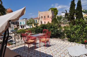 een terras met een tafel en stoelen op een balkon bij Rastoni 1928 in Aegina Town