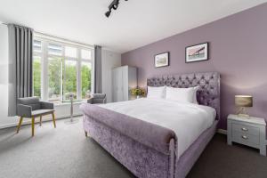 a bedroom with a large bed and a chair at Harbour Hub Hotel in Southampton