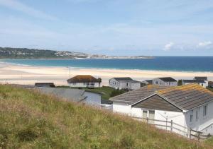 Blick auf einen Strand mit Häusern und das Meer in der Unterkunft D39 St Margarets, Riviere Towans in Hayle