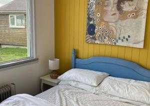 ein Bett mit einem blauen Kopfteil in einem Schlafzimmer in der Unterkunft D39 St Margarets, Riviere Towans in Hayle
