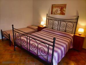 een slaapkamer met een bed met een paarse sprei bij Villa Etruria Guest House in Pitigliano