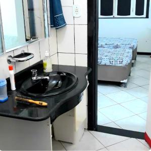 a bathroom with a black sink and a bed at Um castelo só pra você! 