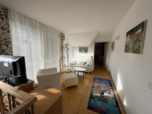 a living room with a couch and a tv at Ferienhaus Gansbach in Gansbach