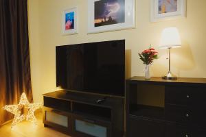 a living room with a flat screen television on a dresser at Big Apartment in Turda