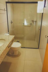 a bathroom with a shower and a toilet and a sink at Grande Hotel Guarapuava in Guarapuava