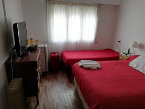 a hotel room with two beds and a television at Necochea Real Hotel in Necochea