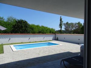 a view of a swimming pool in a backyard at More i Sol Rab Pool House in Rab