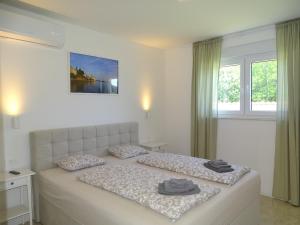 a bedroom with a bed with two pillows on it at More i Sol Rab Pool House in Rab +23 photos