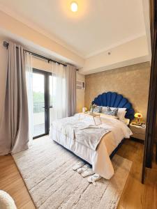 ein Schlafzimmer mit einem großen Bett mit blauem Kopfteil in der Unterkunft Twinlakes Tagaytay Vinesera Manor1 3F in Balibaguhan
